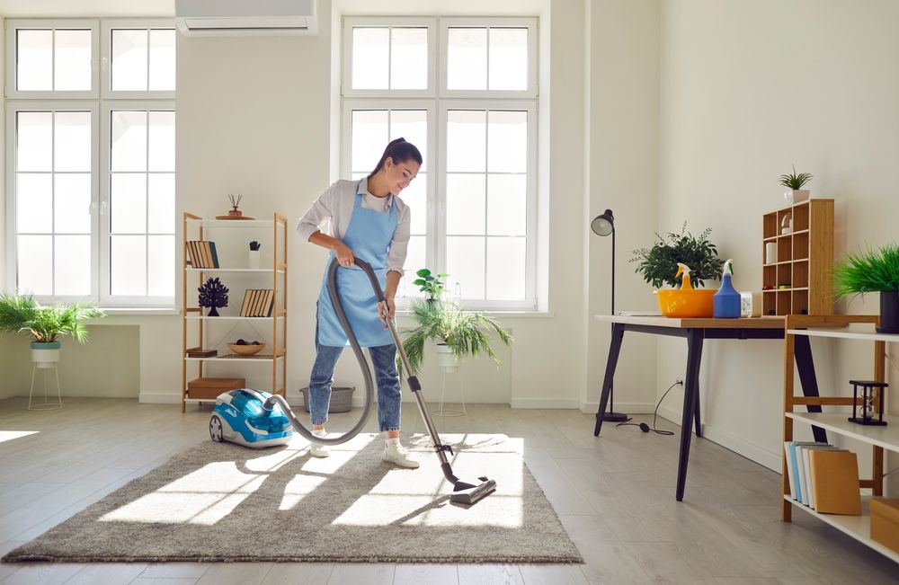 A homeowner vacuuming a bright living room